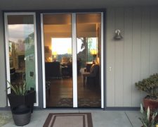 TALL WHITE FRENCH ROLL-AWAY RETRACTABLE SCREEN DOORS IN USE