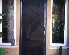 TALL BRONZE ROLL-AWAY DISAPPEARING SCREEN DOOR IN USE