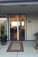 TALL WHITE FRENCH ROLL-AWAY RETRACTABLE SCREEN DOORS IN USE