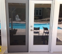 WHITE FRENCH ROLL-AWAY SCREEN DOORS WITH FIXED DOOR LOCKED IN PLACE