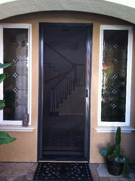 TALL BRONZE ROLL-AWAY DISAPPEARING SCREEN DOOR IN USE