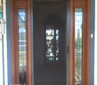 BRONZE ROLL-AWAY DISAPPEARING SCREEN DOOR IN USE