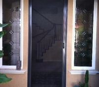 TALL BRONZE ROLL-AWAY DISAPPEARING SCREEN DOOR IN USE