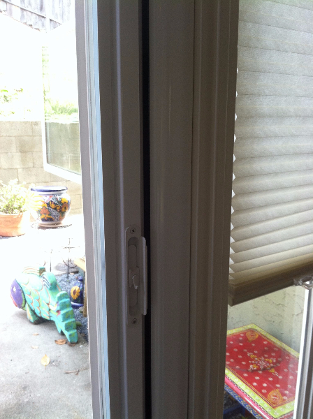 WHITE ROLL-AWAY SCREEN DOOR FLUSH WITH DOOR MOULDING ON DOOR THAT SWINGS OUT